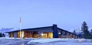 The outside of a Forest Service building during winter, with snow and overcast sky.